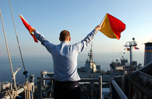 US_Navy_051129-N-0685C-007_Quartermaster_Seaman_Ryan_Ruona_signals_with_semaphore_flags_during_a_replenishment_at_sea